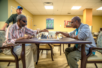 A Veteran sitting and talking with his caregiver at home 