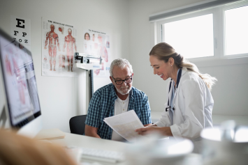 A person speaks to their doctor as they walk through a medical waiting room.