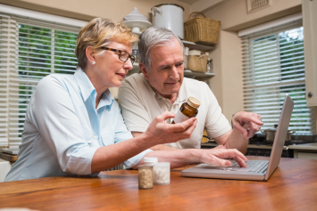 A person shows a pharmacist their prescription info on a mobile phone.