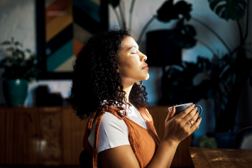 A person meditates in a dark room.