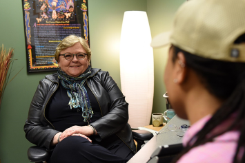 A VA social worker in their office sits and talks to a Veteran.