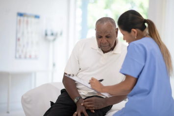 A medical profession reviews health information with a Veteran.